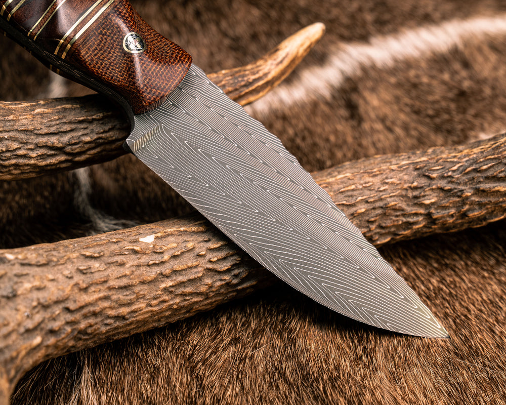 Crow Jr- Vegas Forge Herringbone Damascus, Brown Canvas Micarta, Natural Micarta, Black G10, Brass and Fiddleback Jarrah Split, Mahogany Over Mountain Ash, Mosaic Pins, Brass Lanyard Pin, Textured Grip